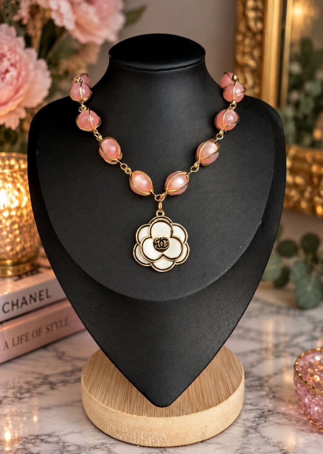 Blush pink pearl-style bead necklace with gold-tone detailing and white floral CC pendant