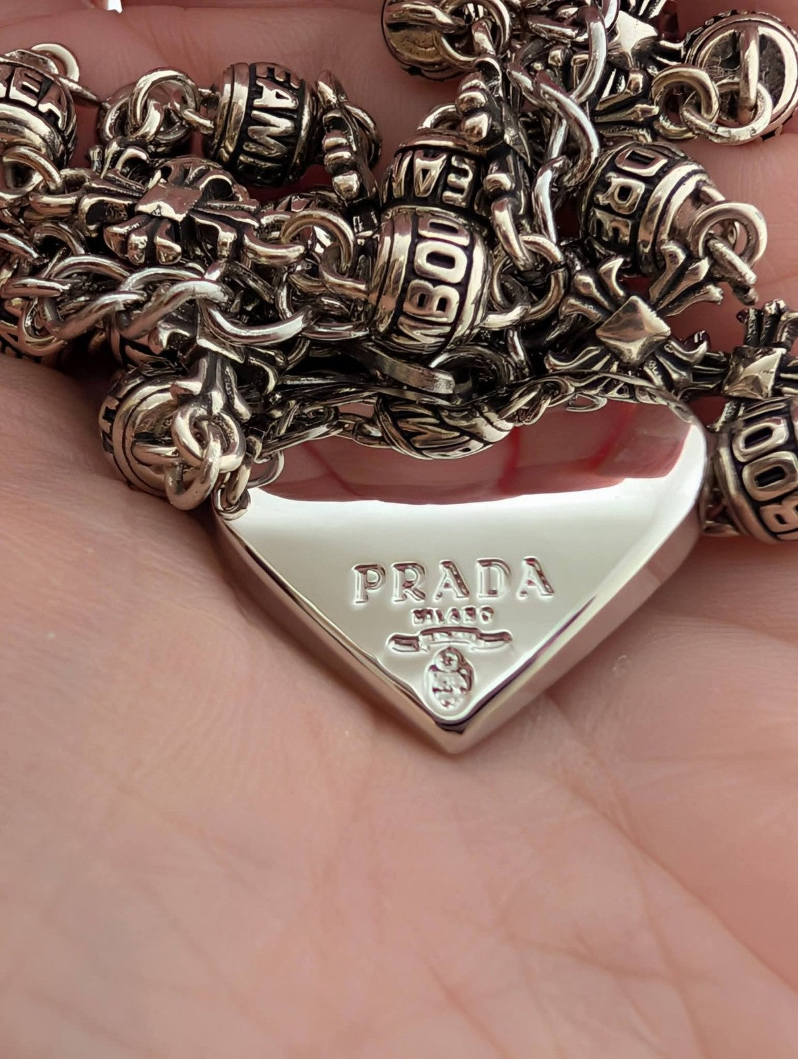 Close-up of the upcycled silver Prada heart and DREAM/BOOTH beads