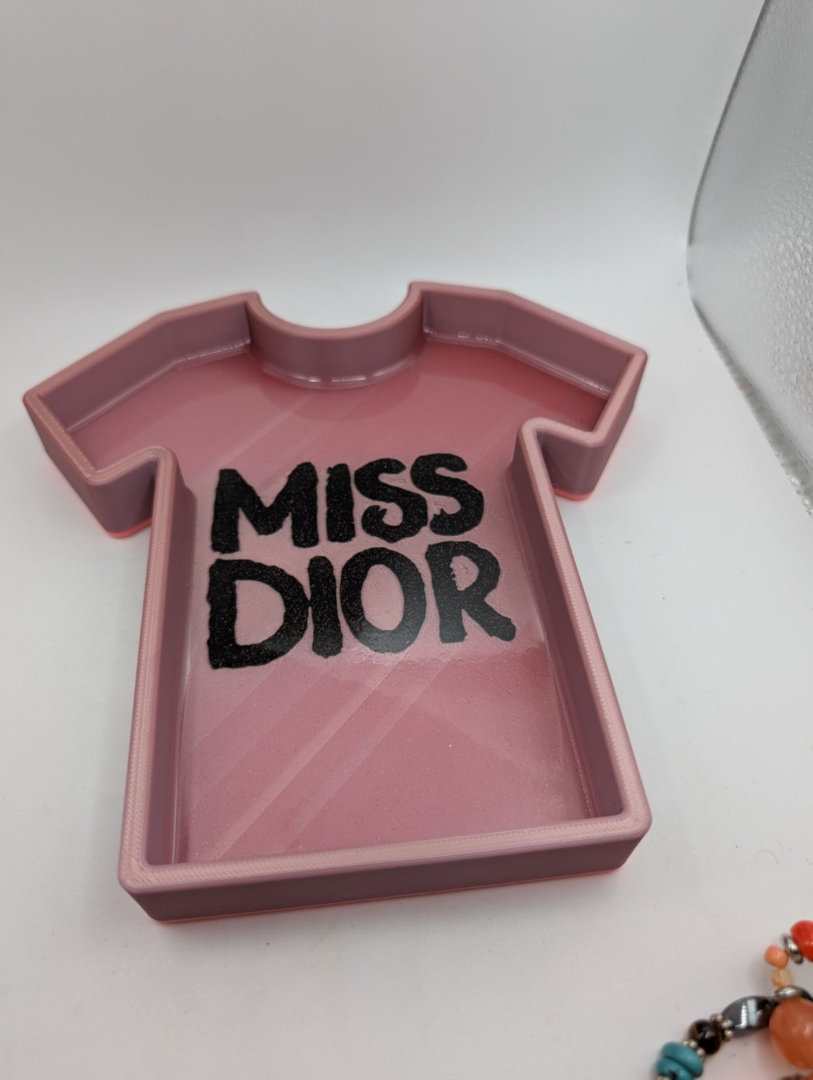 Angled view of the rose-gold glitter tee jewelry tray