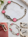 Sterling silver bracelet with two detailed seahorses, three round pink accents, and close-ups of the STERLING stamps.